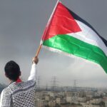 man waving flag আয়ারল্যান্ড, স্পেন ও নরওয়ের প্যালেস্টাইন রাষ্ট্রকে স্বীকৃতি দেওয়ার ঘোষণা