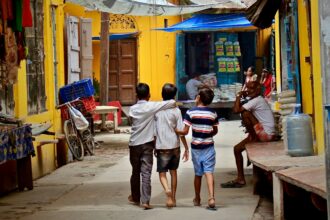 three boys walking between buildings at daytime